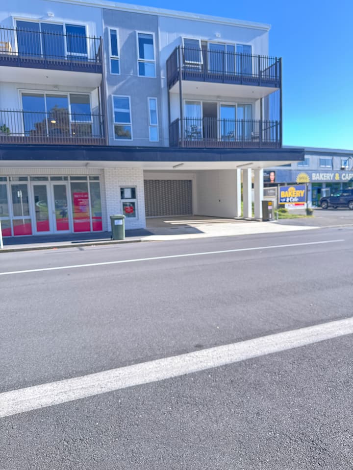 Building exterior with nearby bakery and shops